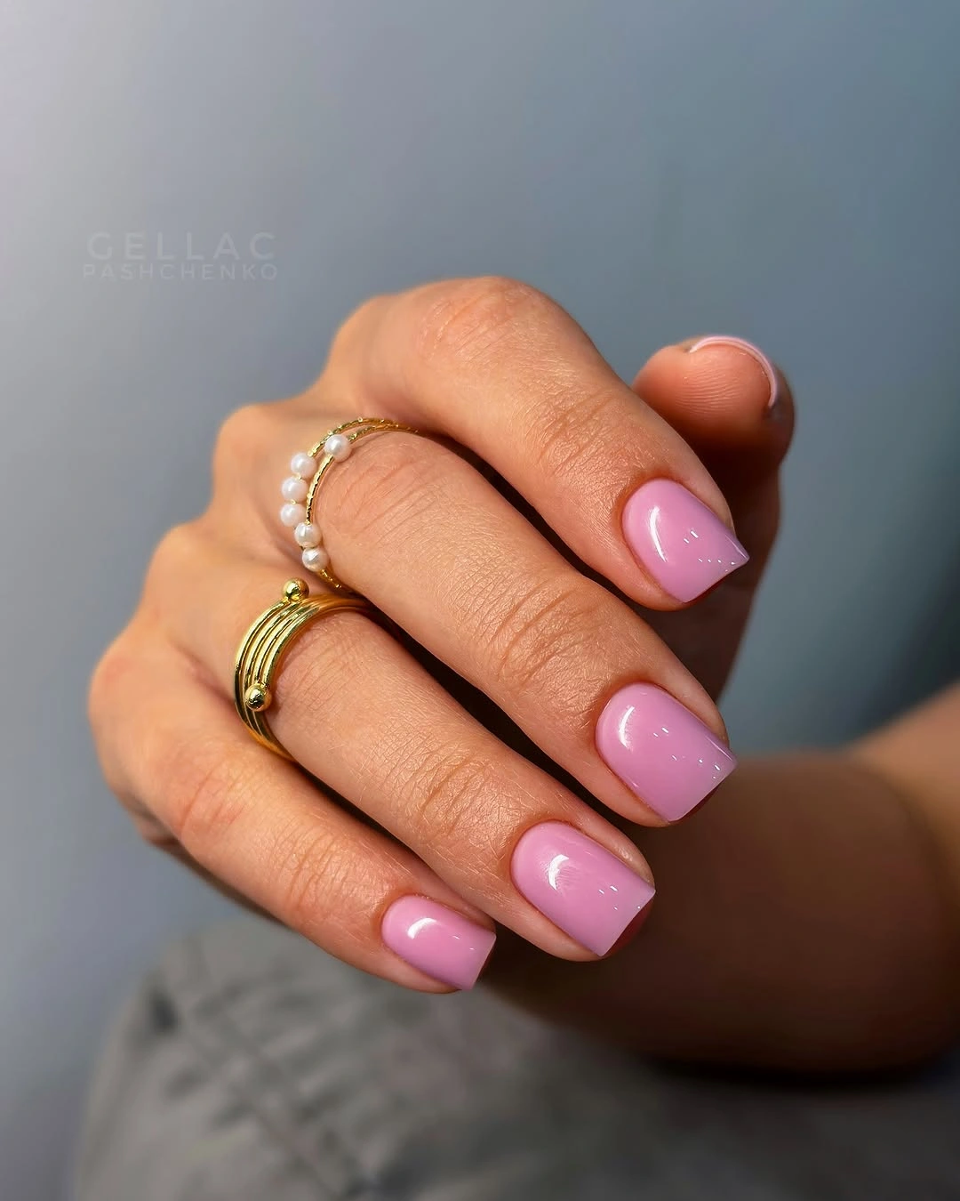 Short bright pink rounded-square nails with glossy shine