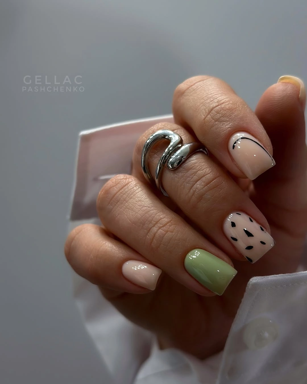 Short square nails with muted green and tiny black dot accents
