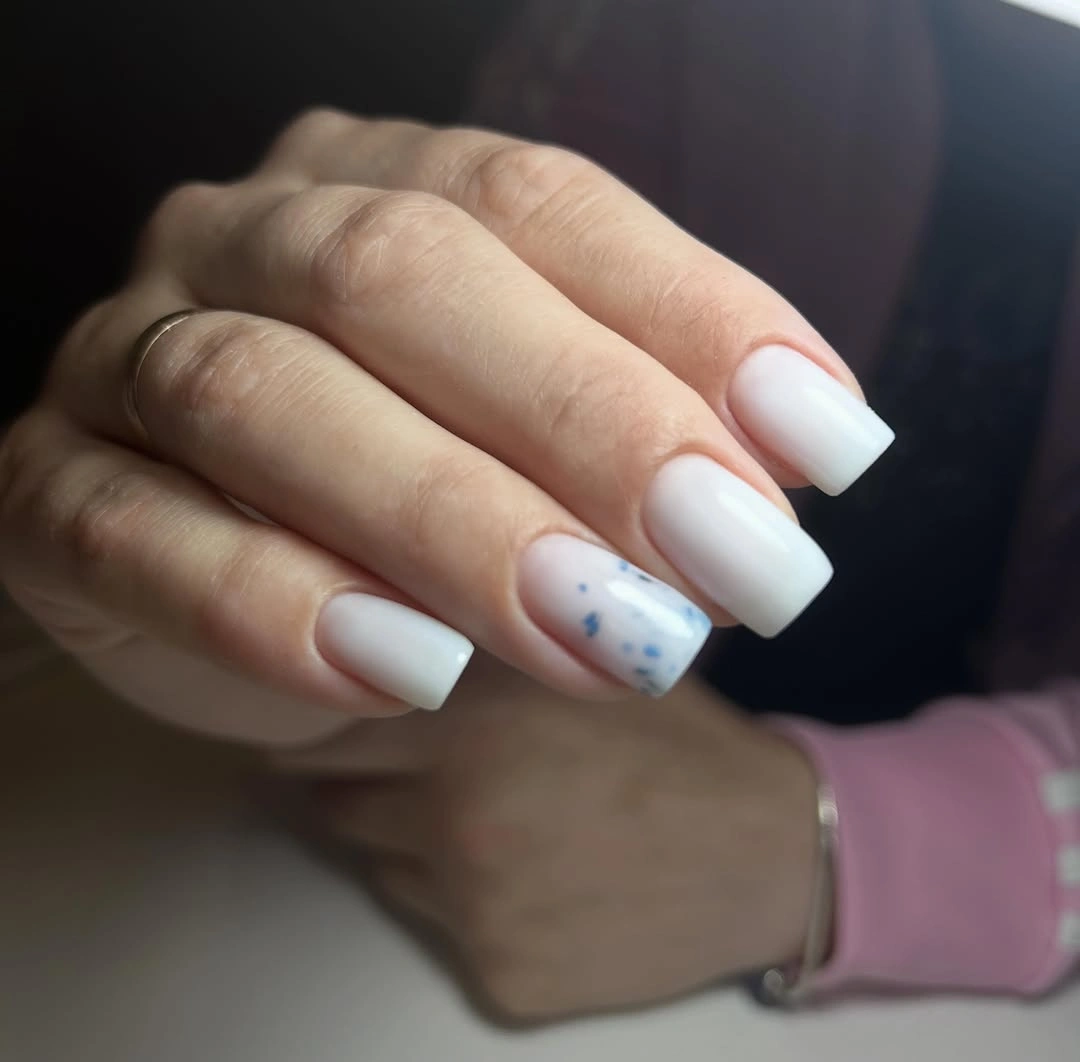 milky white square nails with blue speckled accent
