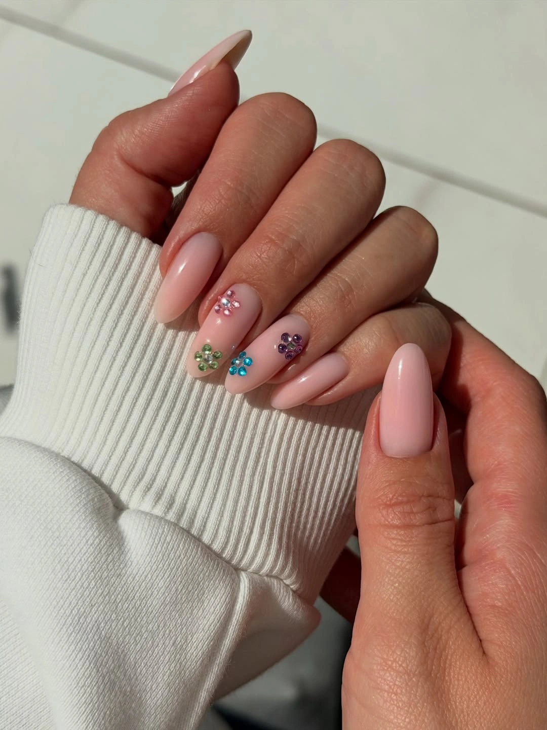 soft pink almond nails with colorful flower accents