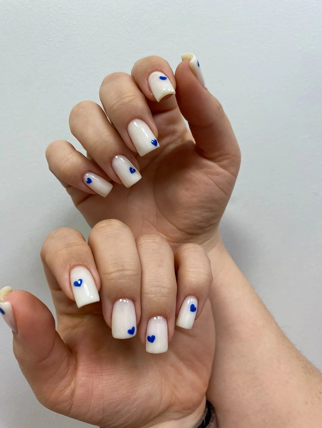 milky white square nails with blue hearts