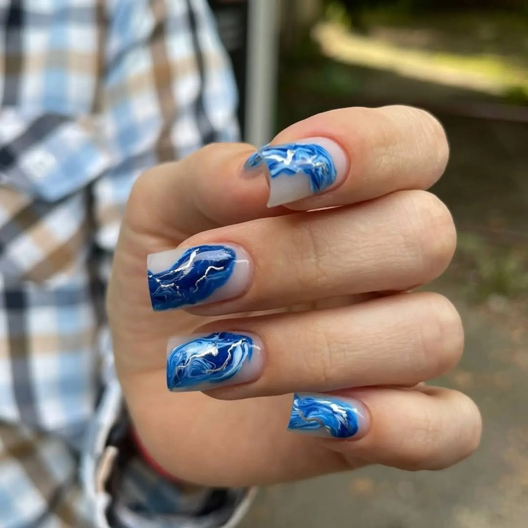 Cobalt blue nails with white swirling accent lines