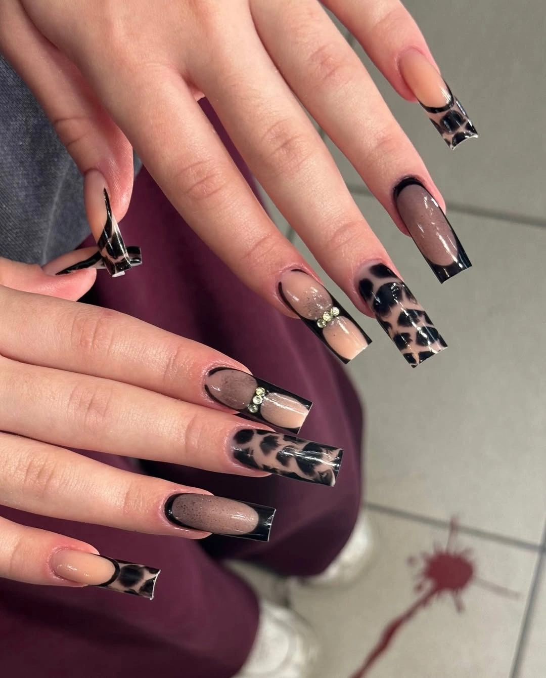 Long nude square nails with black tips and leopard accents