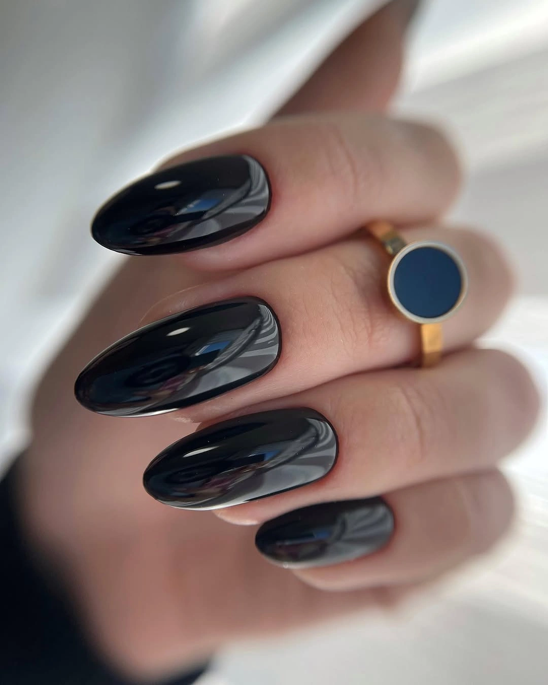 Long glossy near-black navy almond nails with mirror highlights