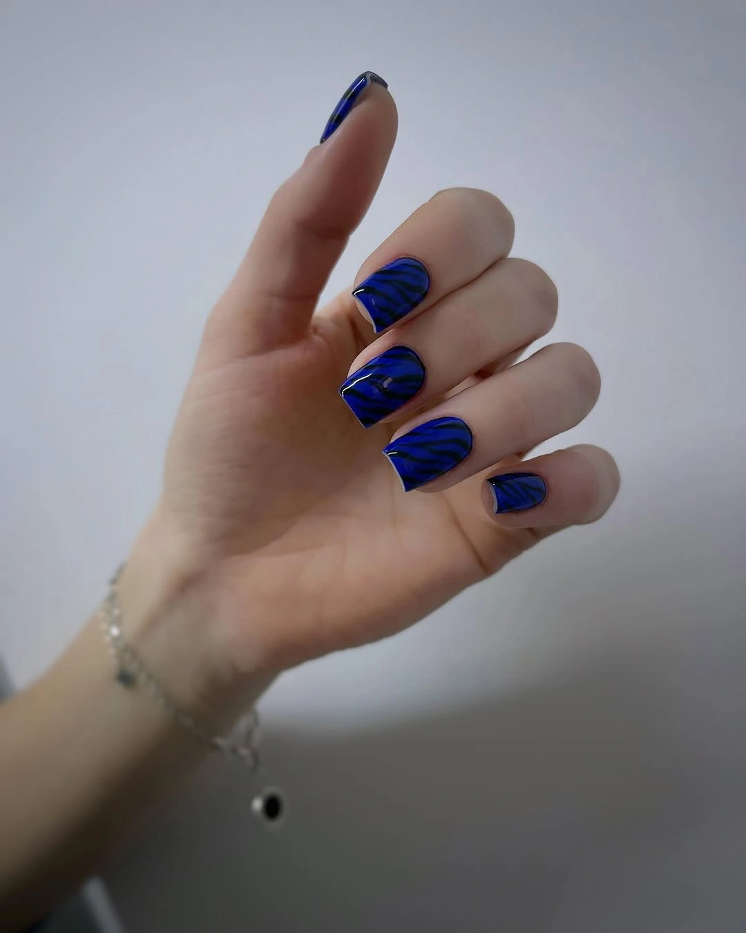 Long electric blue glossy almond nails in a solid finish