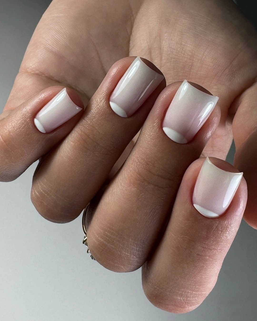 Short milky pink squoval nails with white reverse French crescents