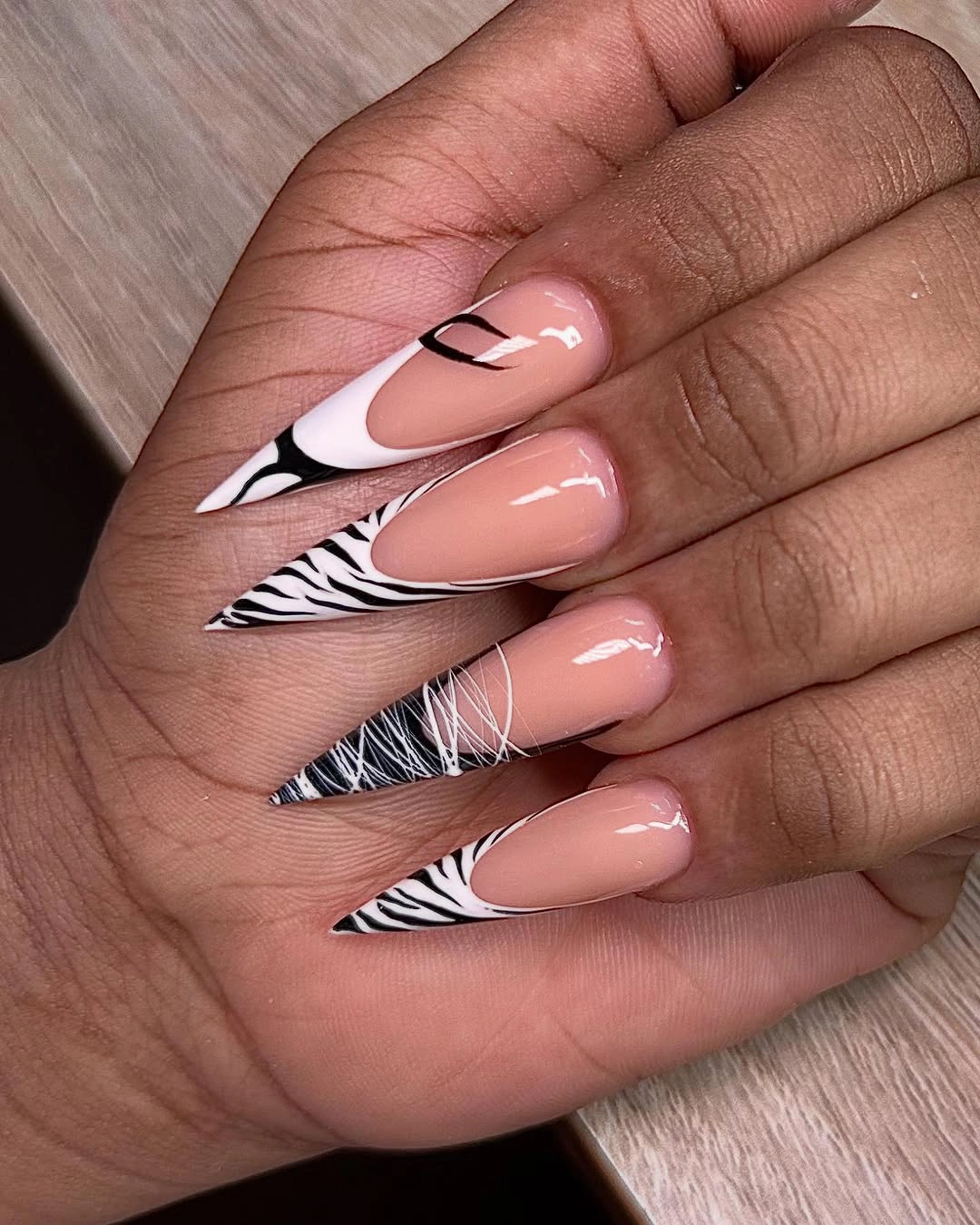 nude stiletto nails with black and white striped tips