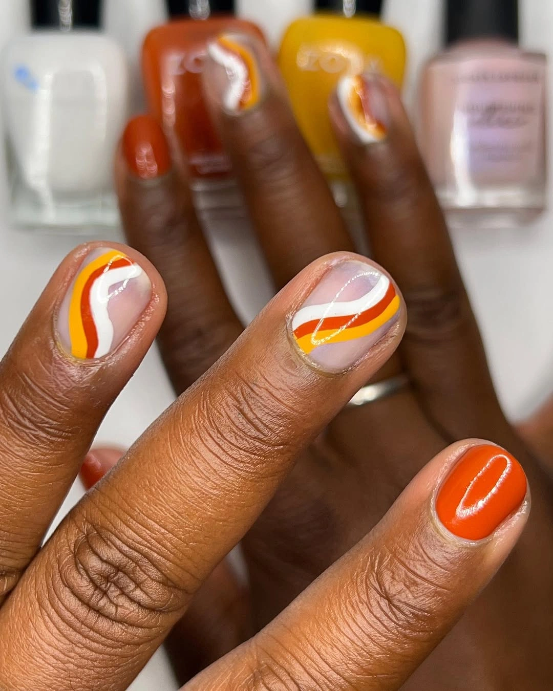 orange square nails with white and yellow abstract lines
