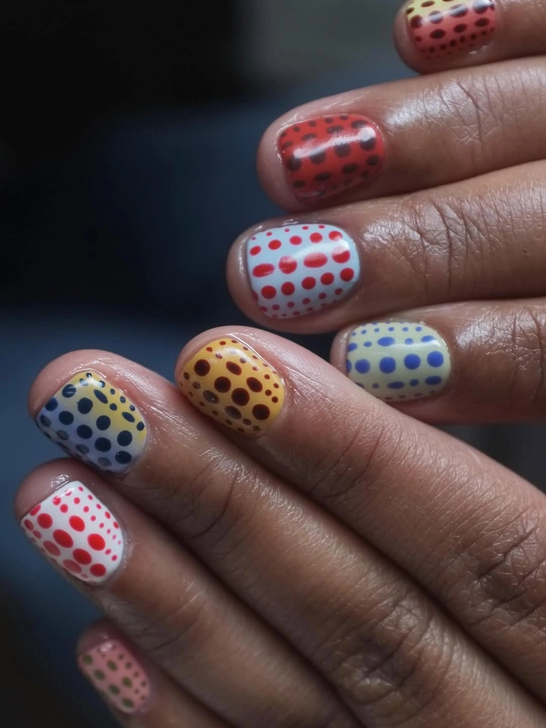 short multicolor nails with red white yellow blue dots