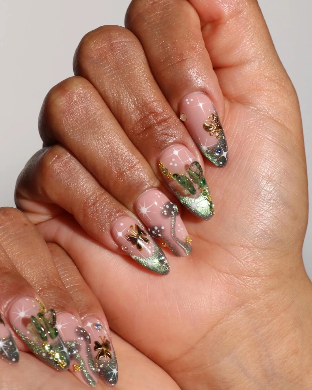 Short almond pink nails with green black and gold micro accents