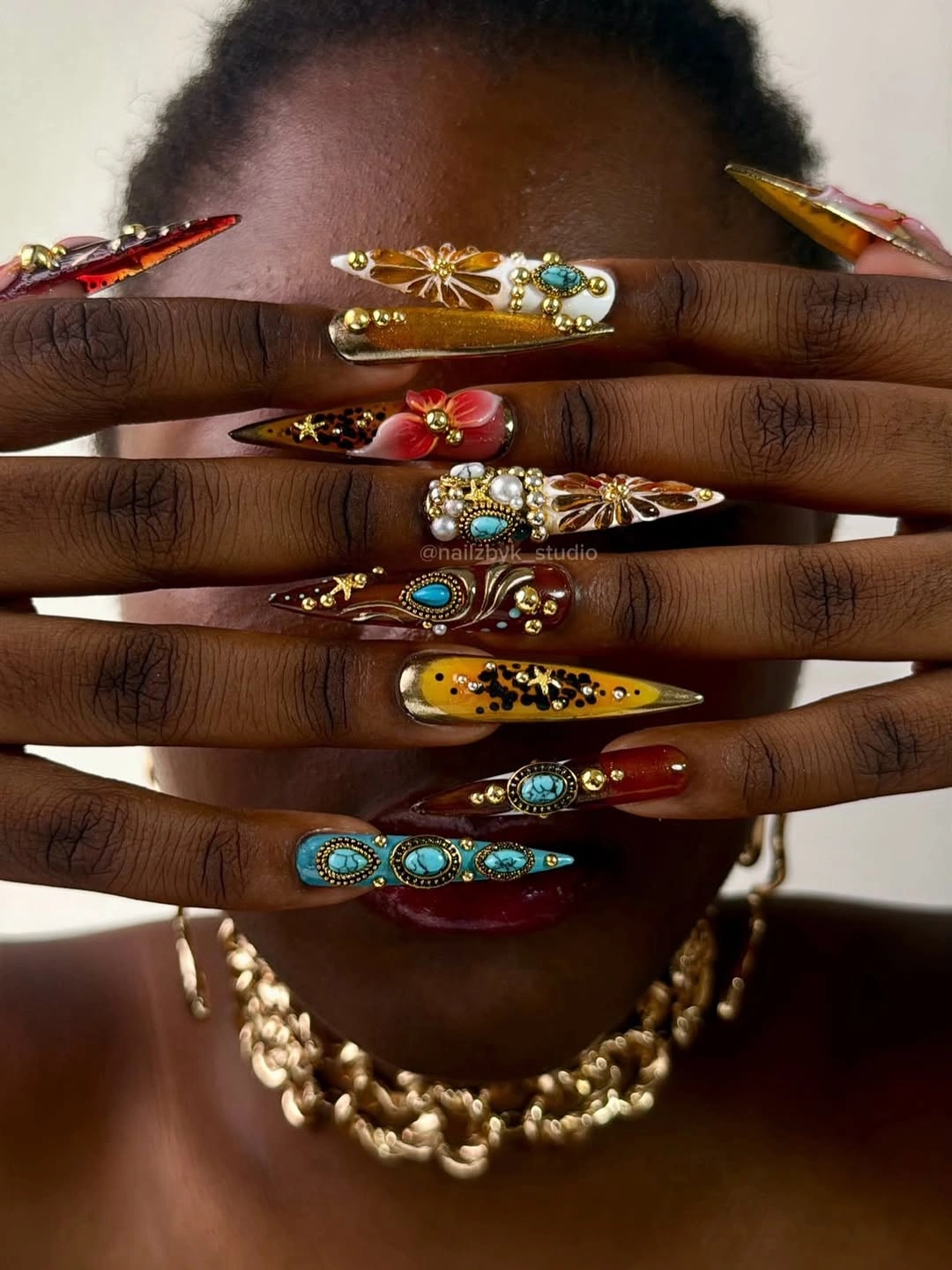 Long multicolor stiletto nails with floral and metallic accents