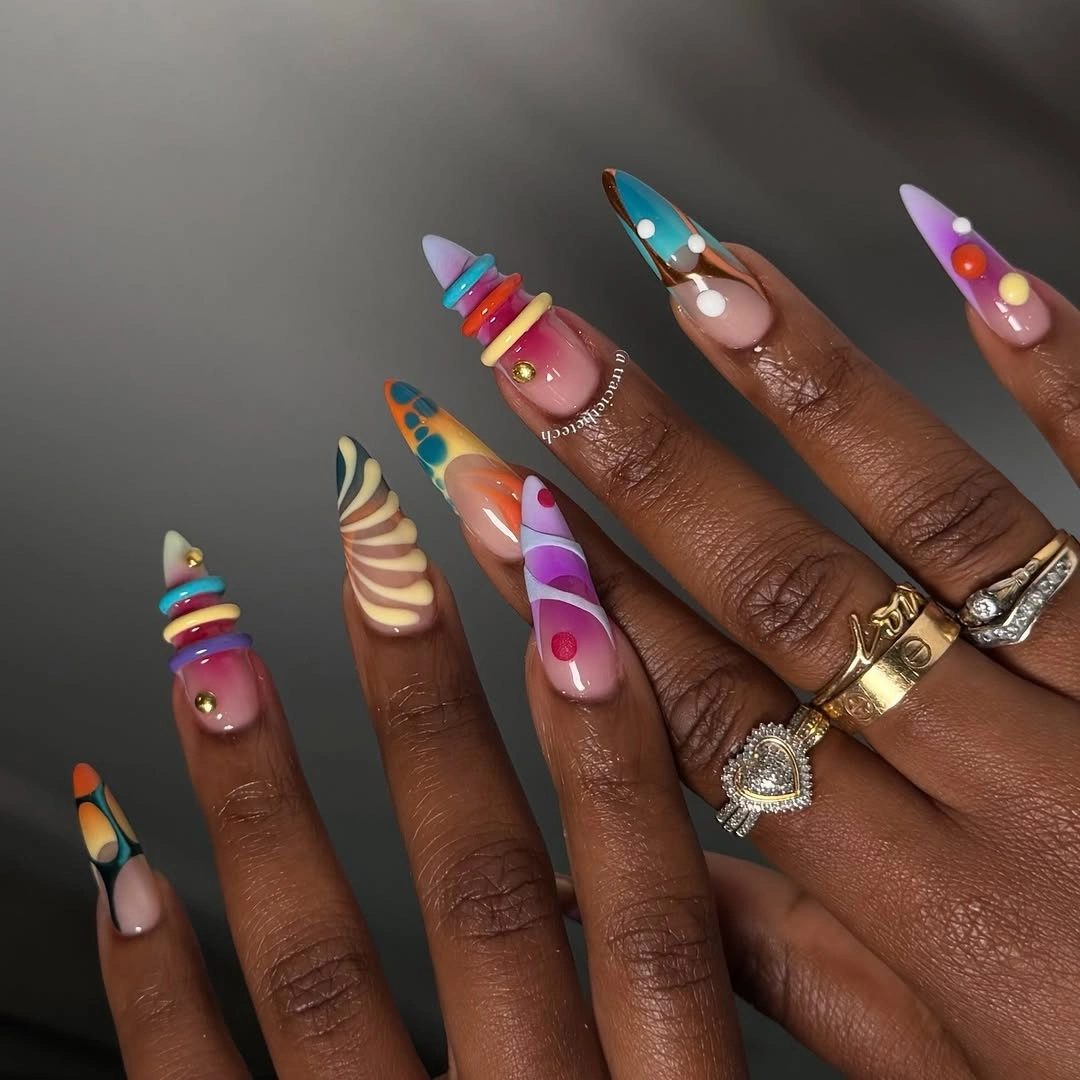 Extreme stiletto nails with rainbow stripes and blue accents