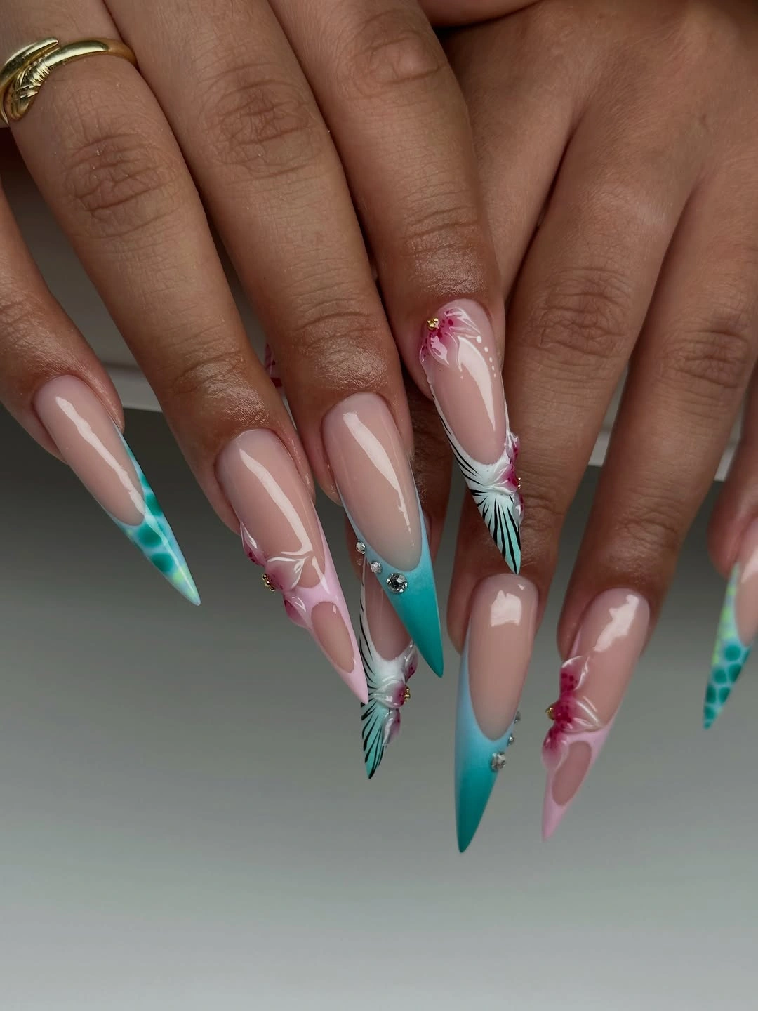 Pale pink nails with turquoise tips and white sweeping accents