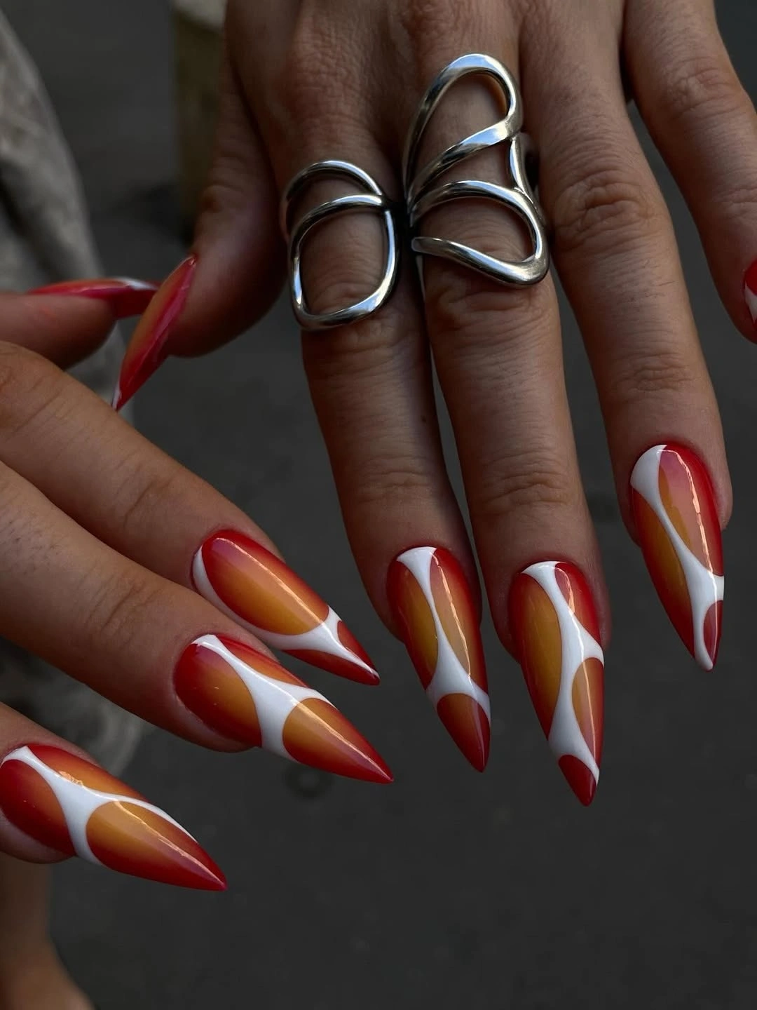 Long red white and orange almond nails with curved panels