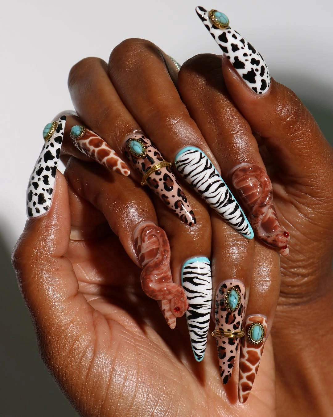 Animal print stiletto nails with zebra spots and turquoise accents
