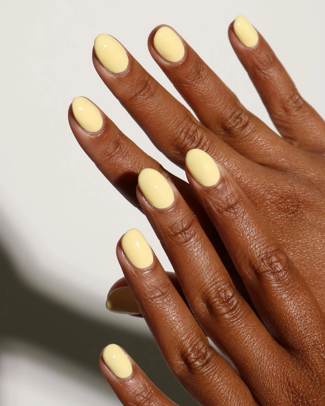 Rounded nails painted a creamy pale yellow for fall