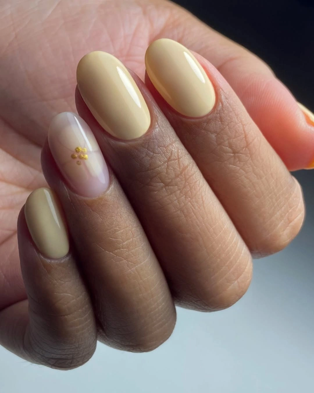 Butter yellow rounded nails with tiny gold accent
