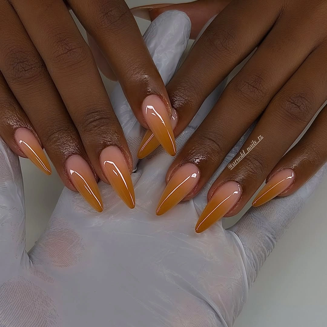Caramel amber ombre stiletto nails on dark skin