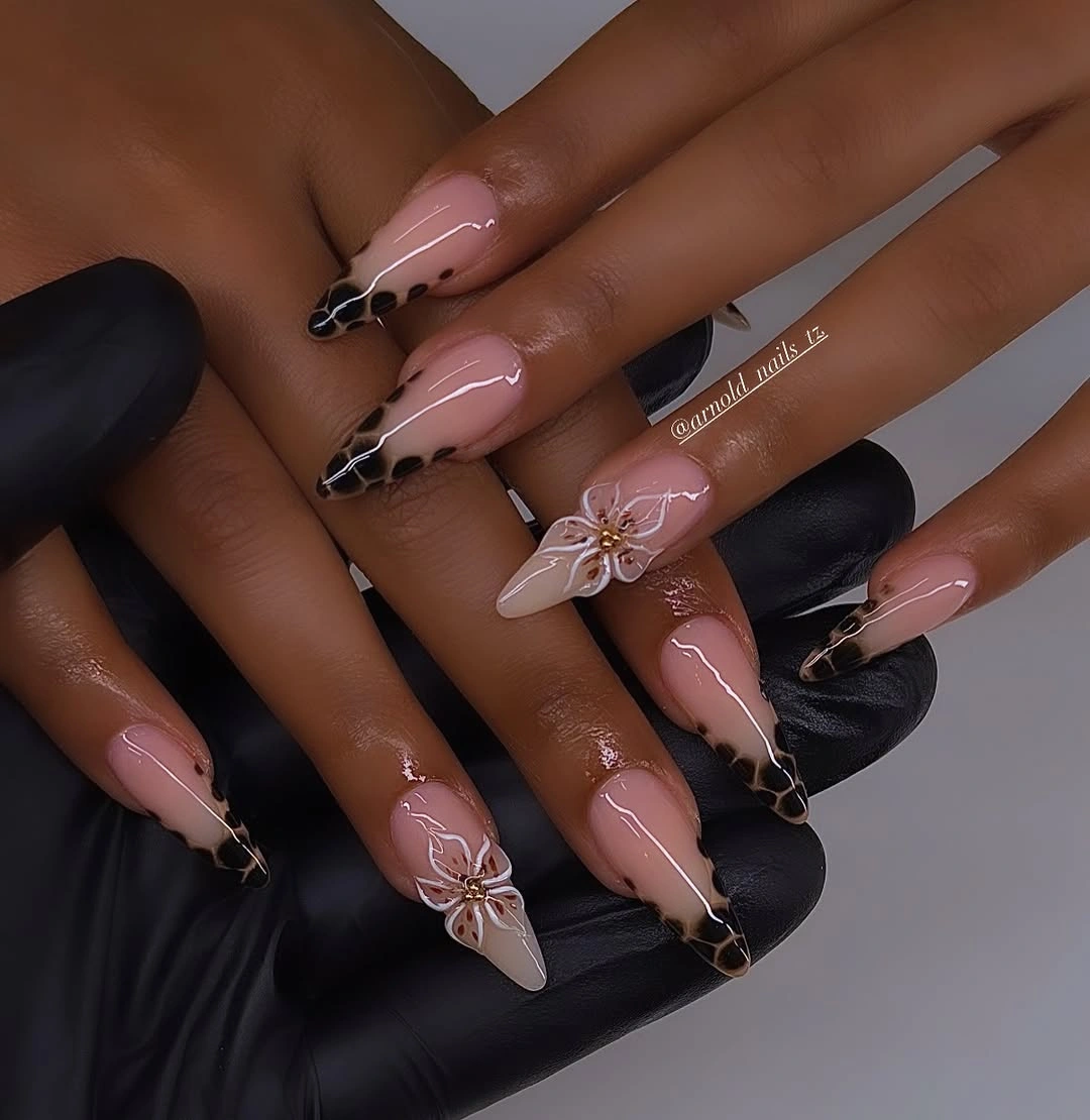 Sheer nude nails with dark spotted tips and flowers