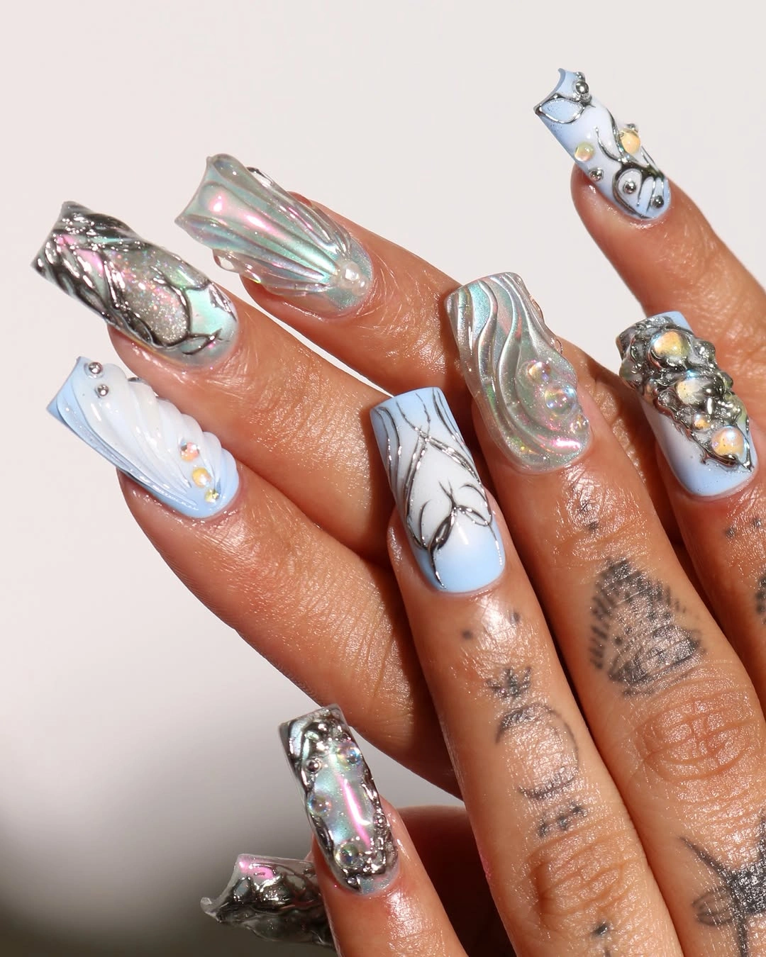 Long pale blue white nails with silver sculptural accents