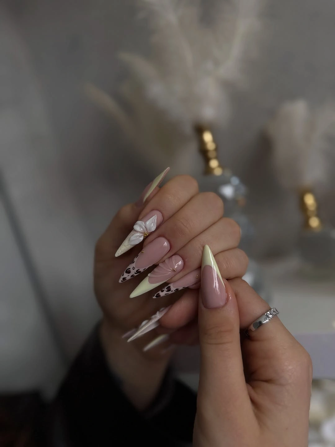 Pale pink almond nails with white lines and tiny gold points