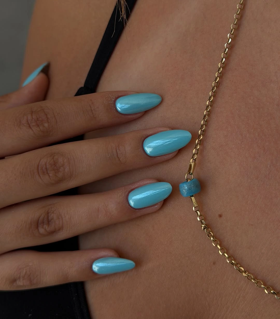Medium rounded nails painted a saturated turquoise blue