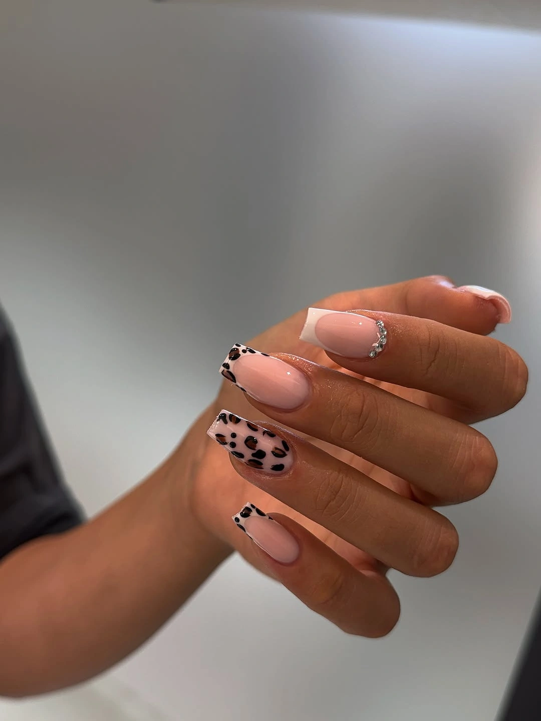 Peach nude almond nails with black spotted accents