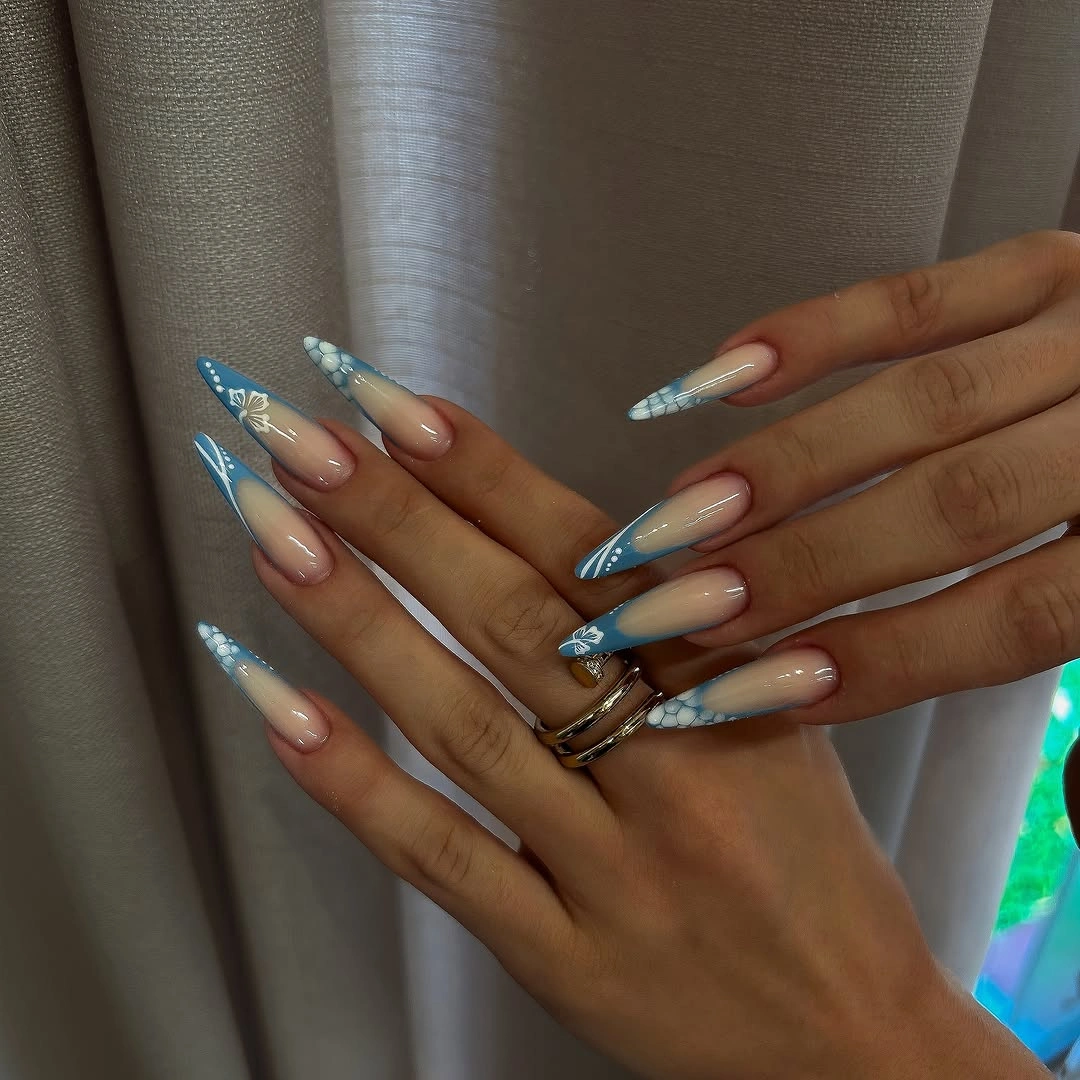 Long pale blue and white almond nails with soft curved accents