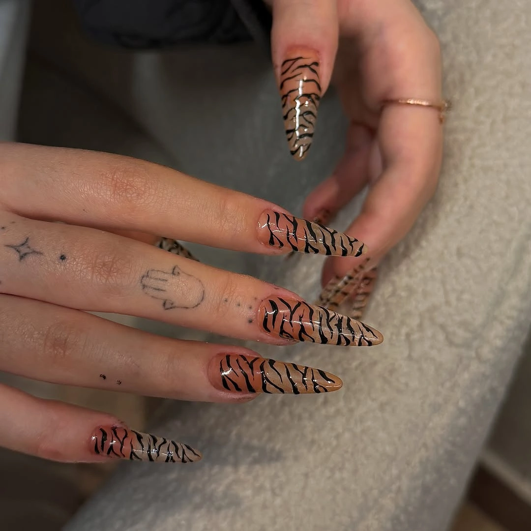 Long narrow nails with brown and black linear stripe pattern