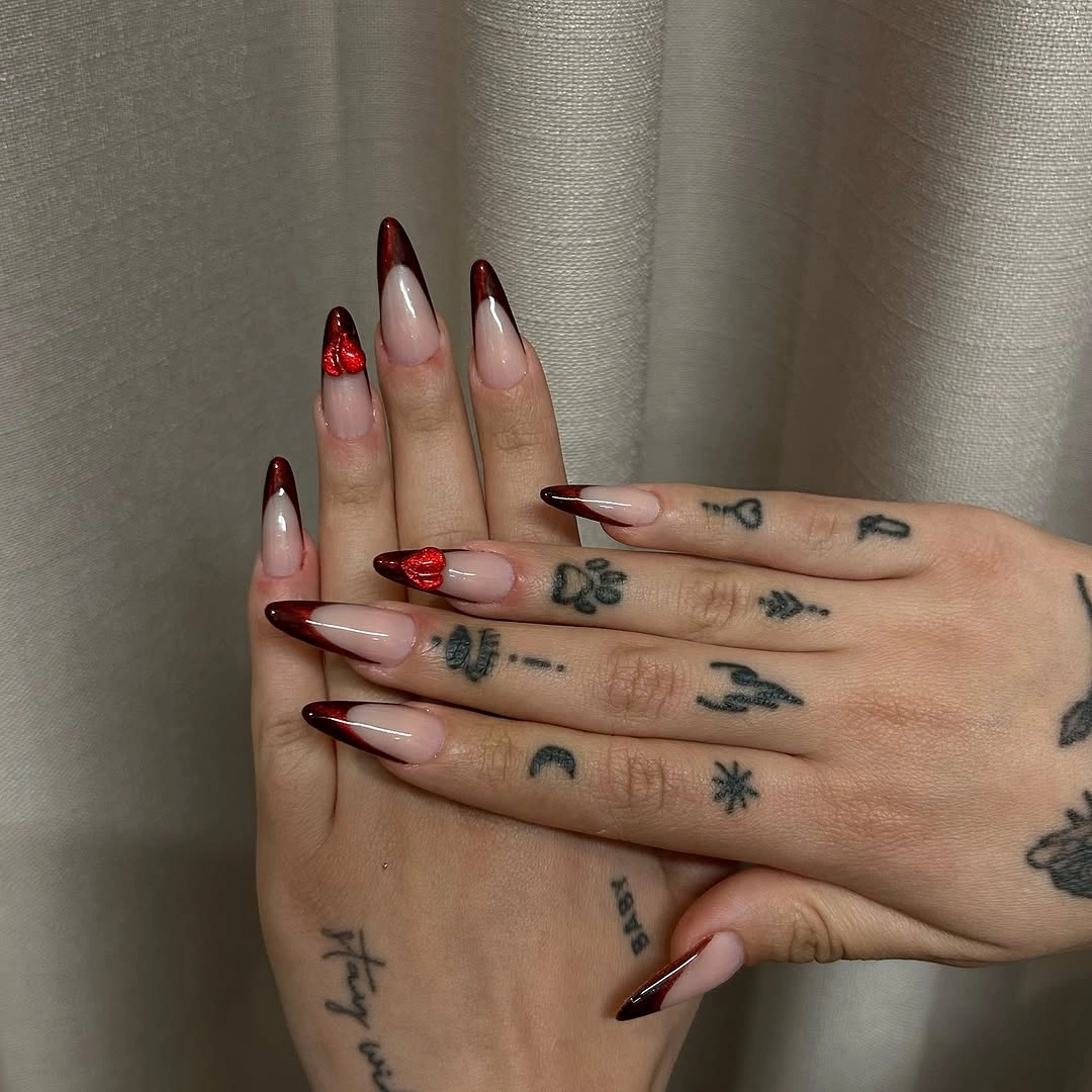 Pale pink almond nails with red tips and tiny floral details
