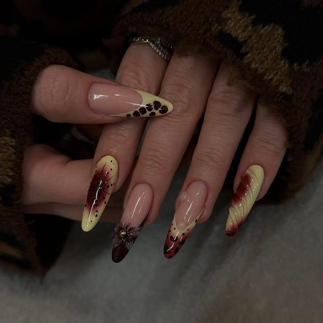 Long almond nude nails with burgundy olive and dark accents
