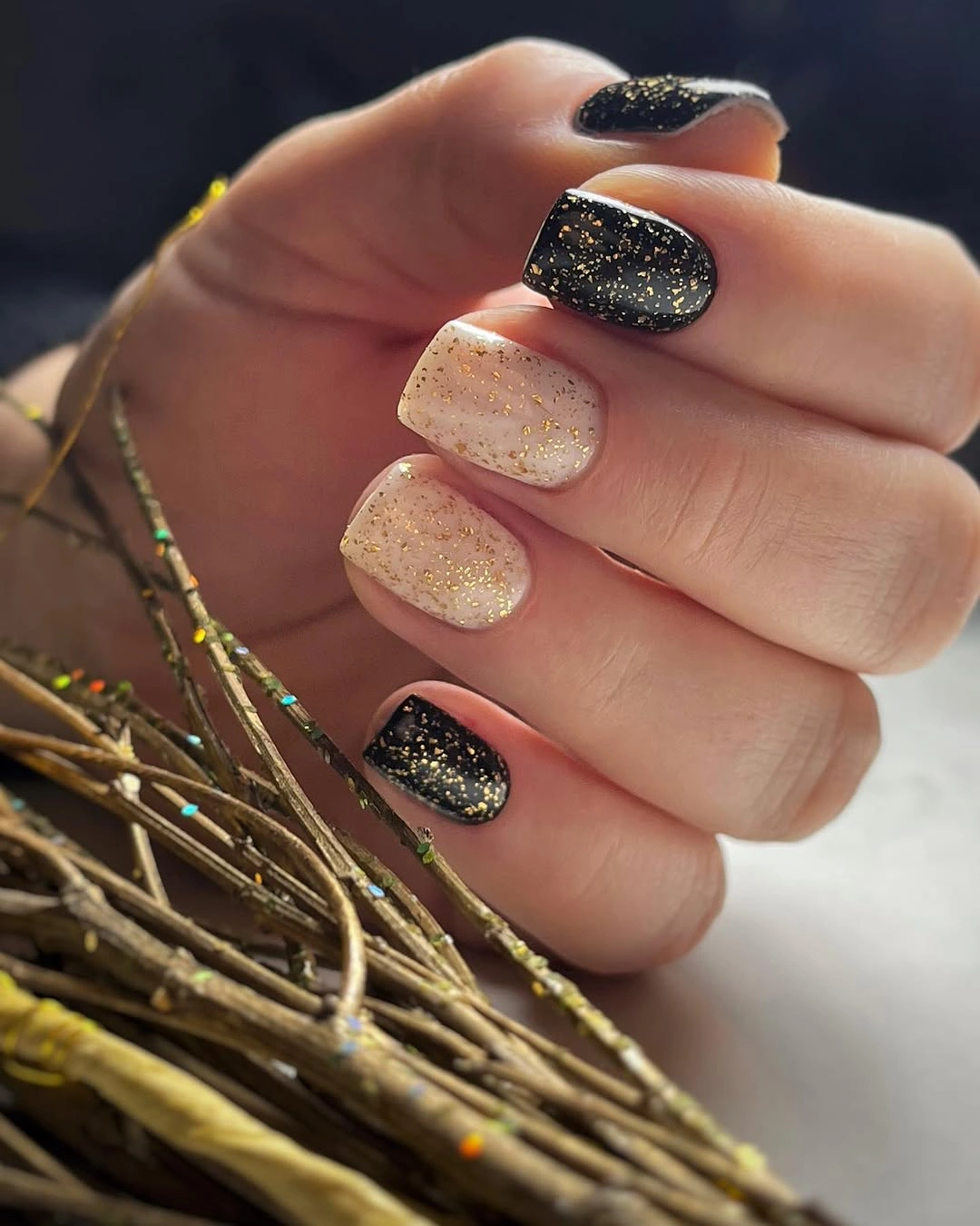Short rounded black and champagne glitter nails