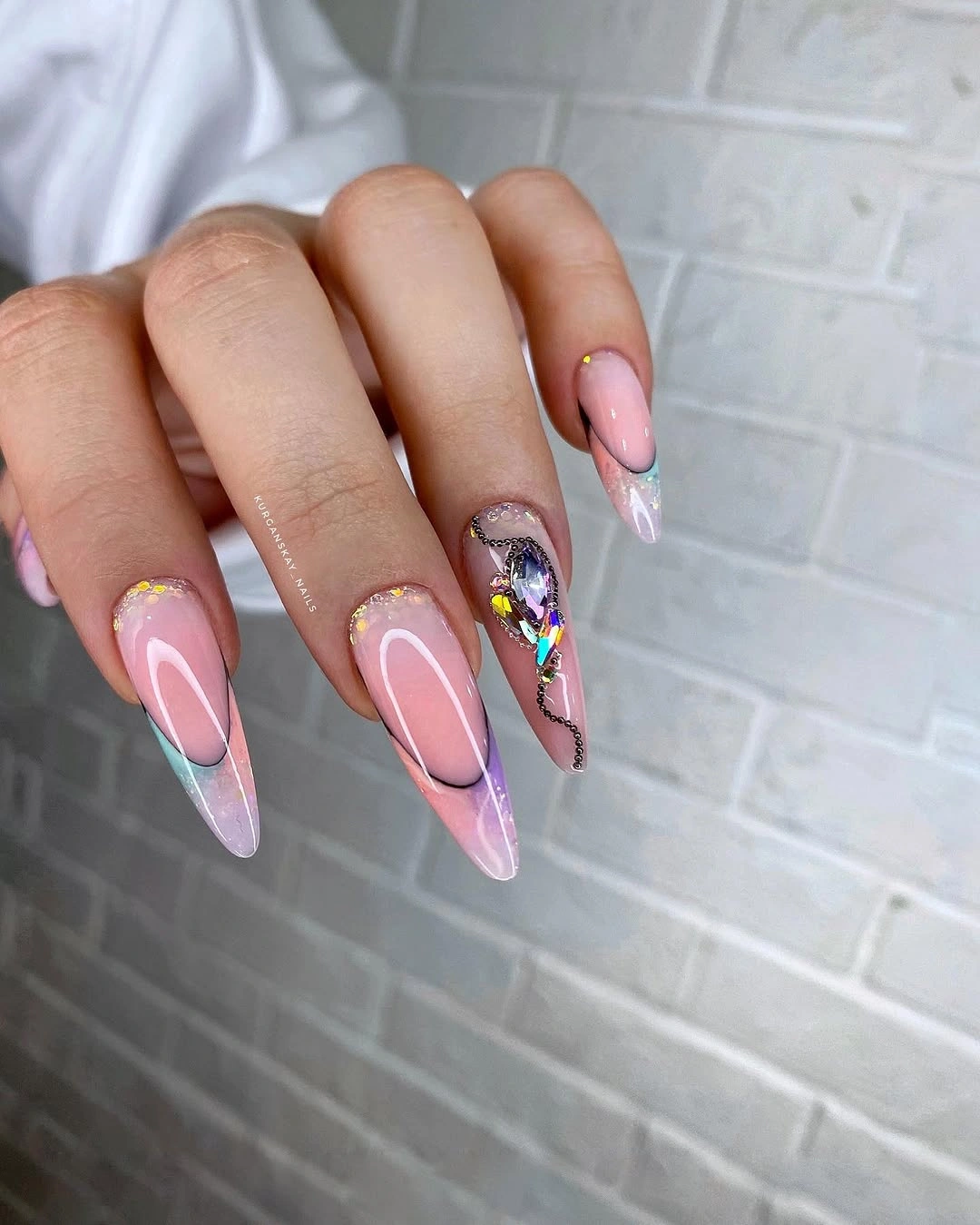 Long pink nails with white contours and a jeweled accent