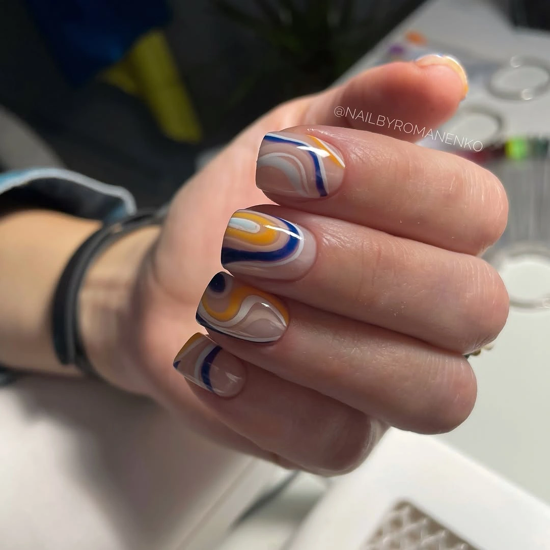 Short squoval nails with navy orange cream swirl lines