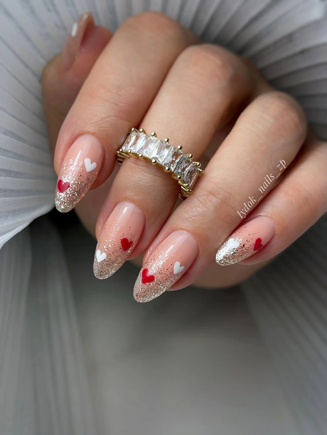 Long almond pink nails with silver glitter tips and hearts