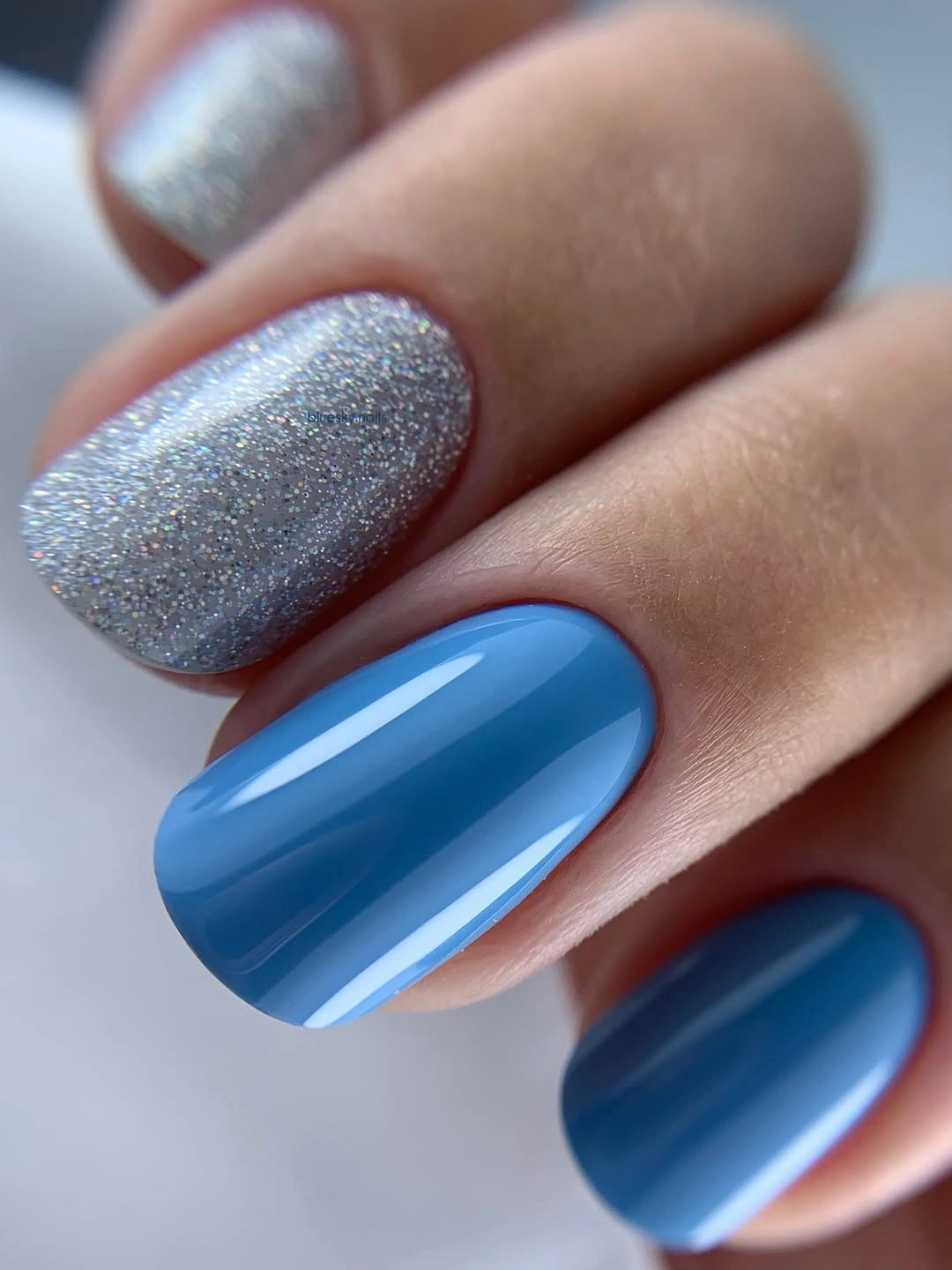Short rounded nails with silver and saturated blue accents