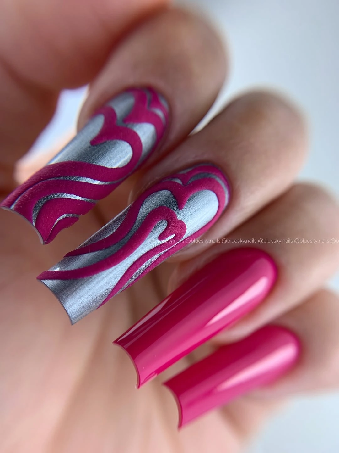 Long pink nails with magenta blue and silver waves