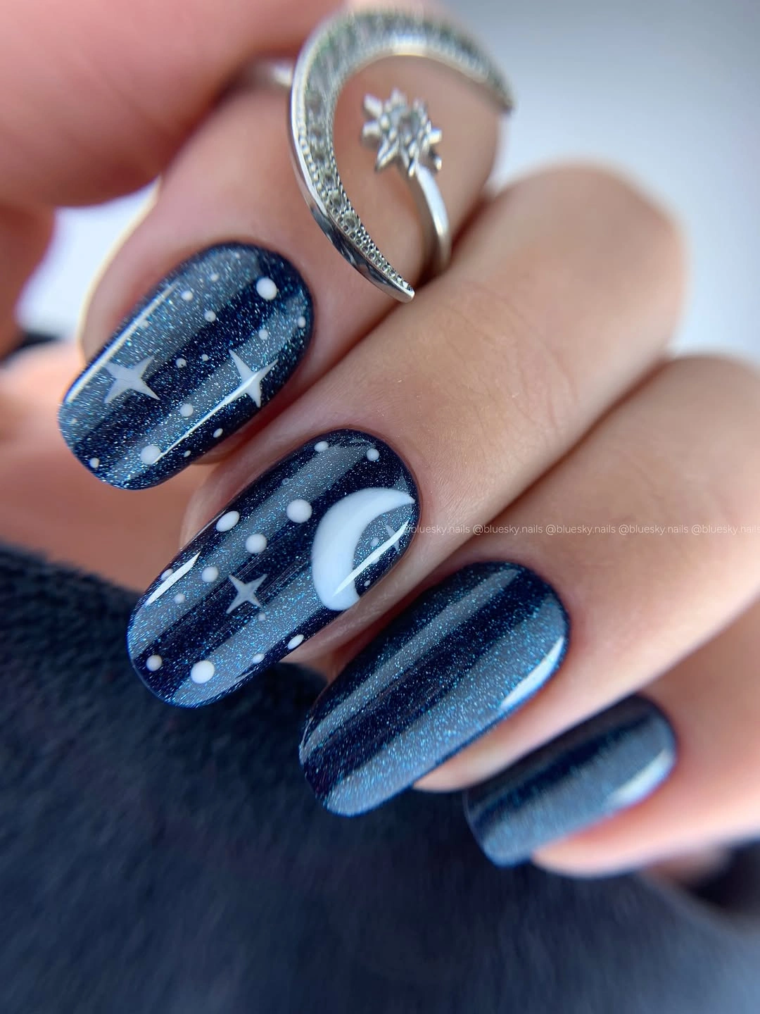 Dark blue nails with pale dots stars and fine lines