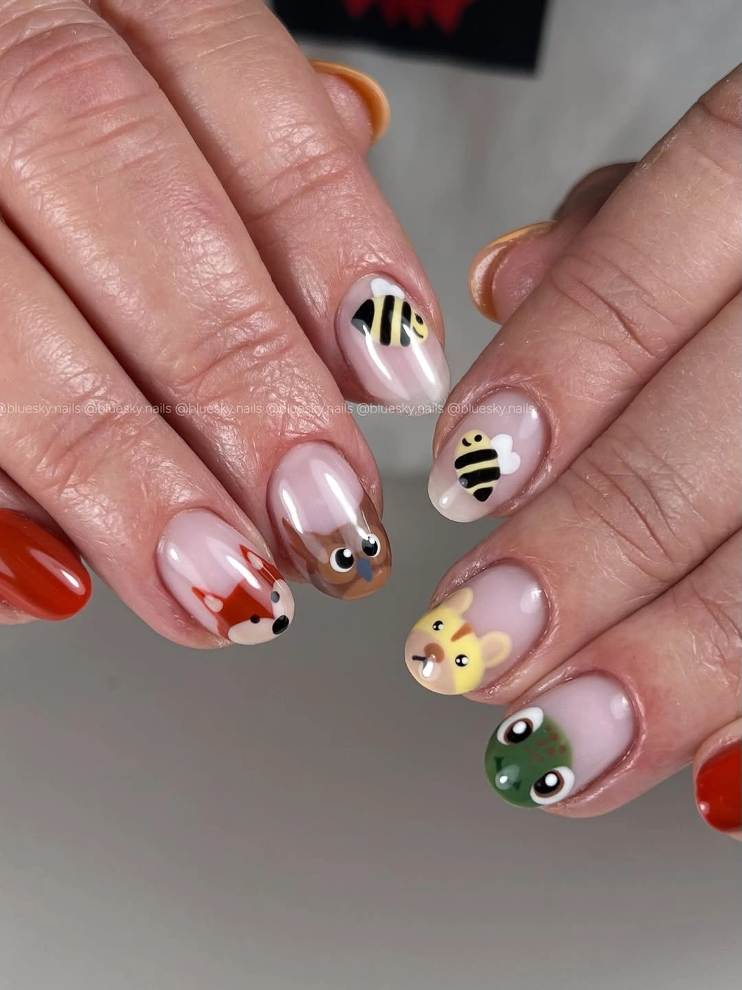Short pink nails with tiny colorful playful illustrated accents