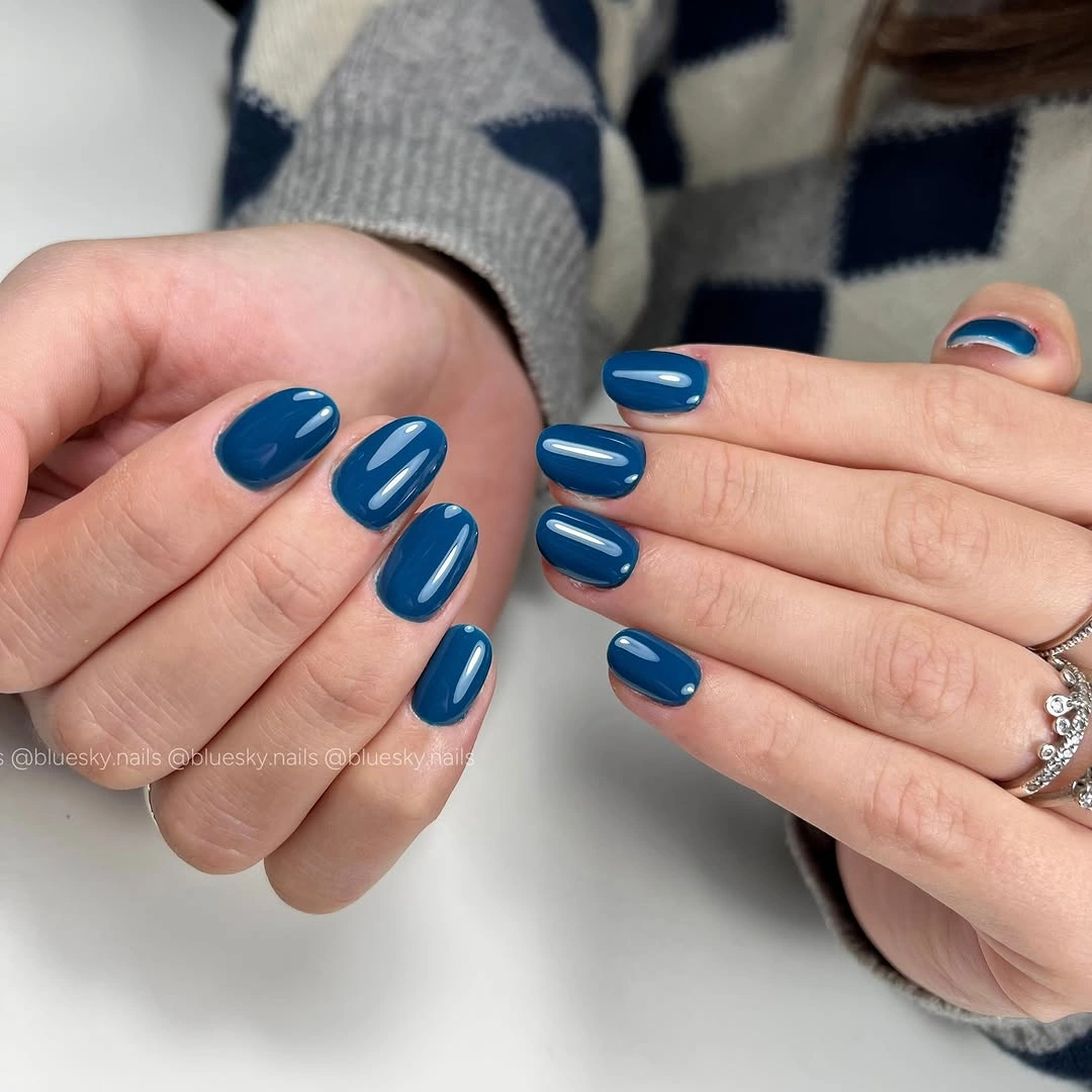 Short rounded navy blue nails with a glossy solid finish