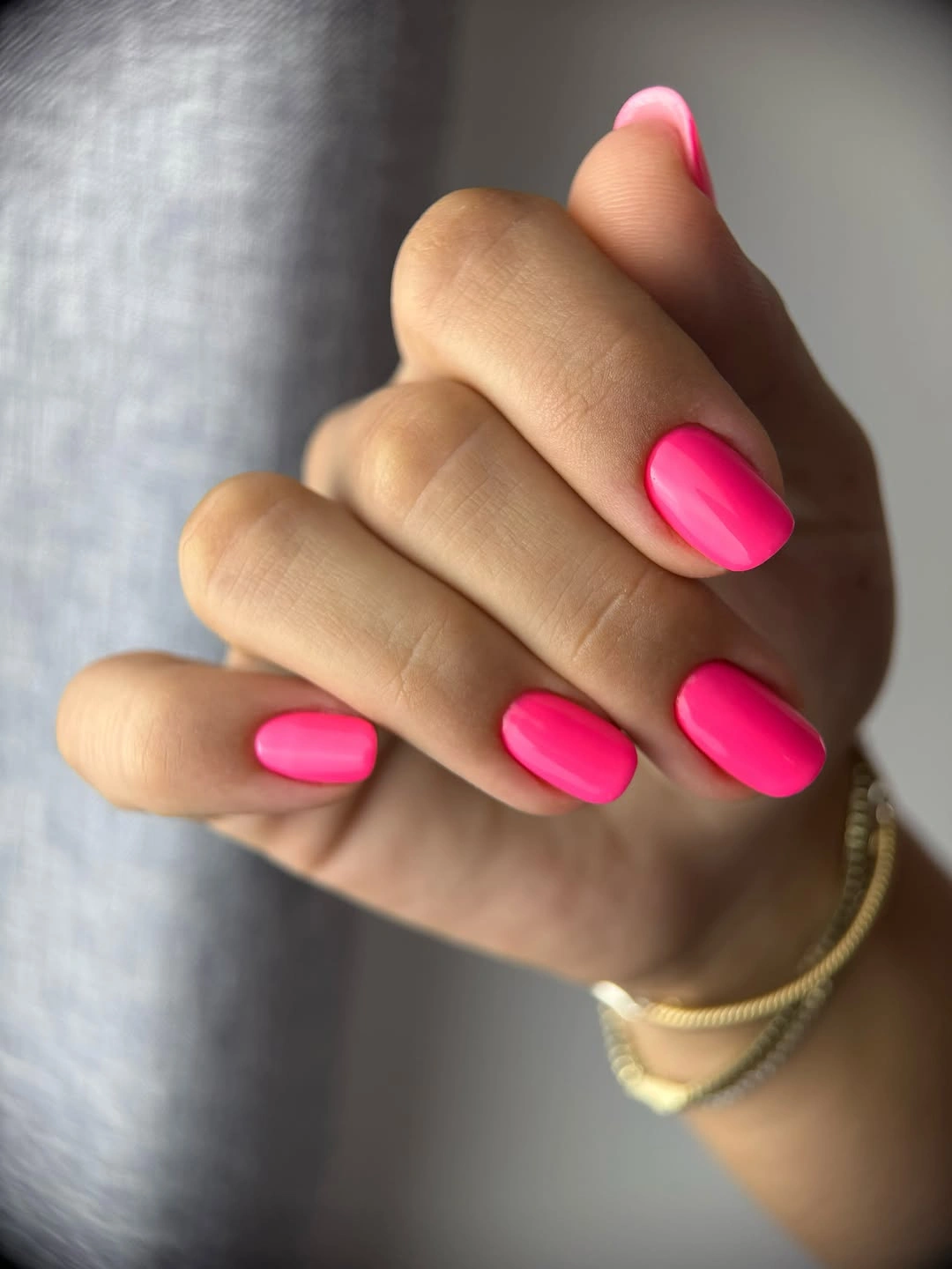Medium rounded nails painted a vivid solid hot pink