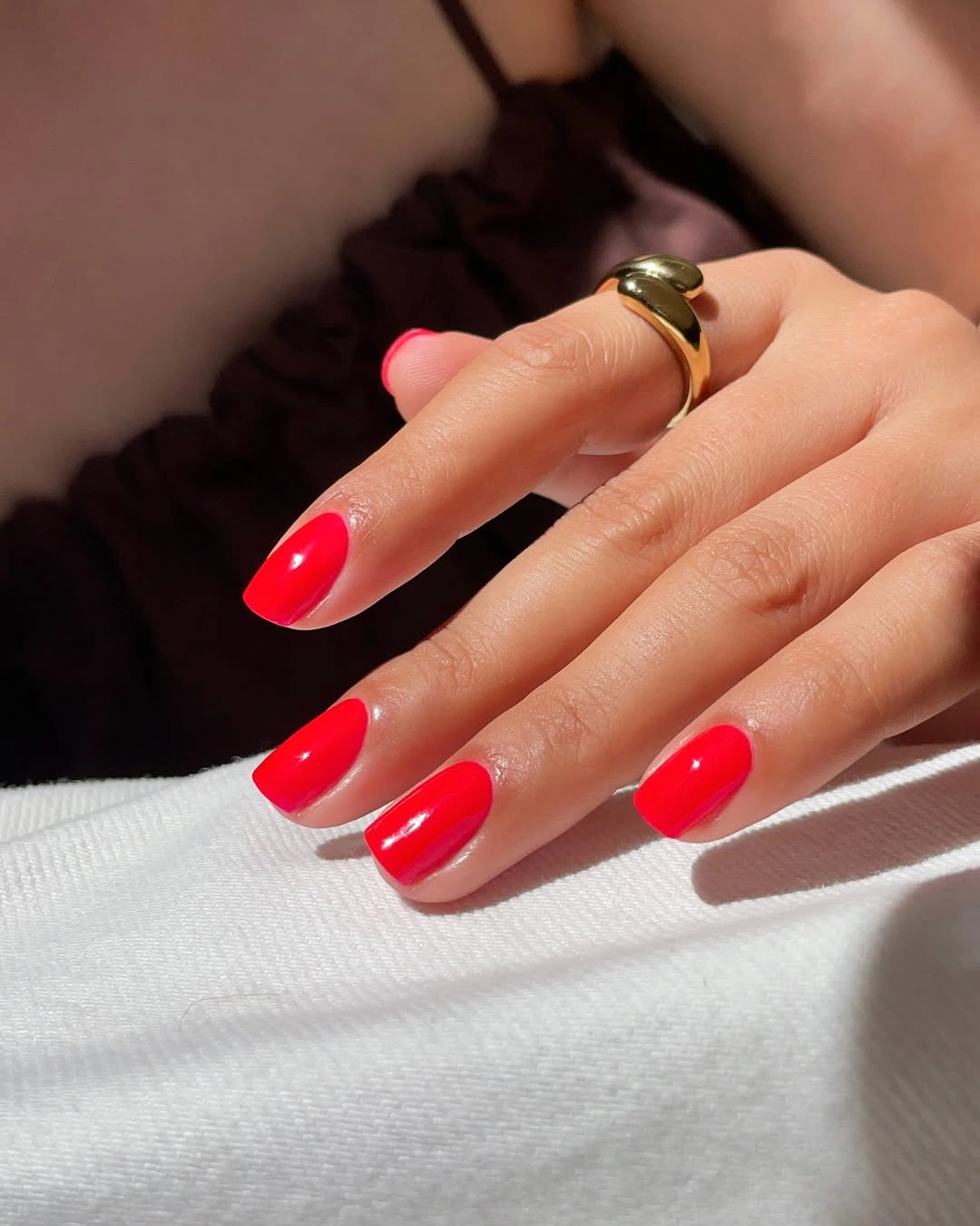 Medium almond nails painted a saturated glossy red
