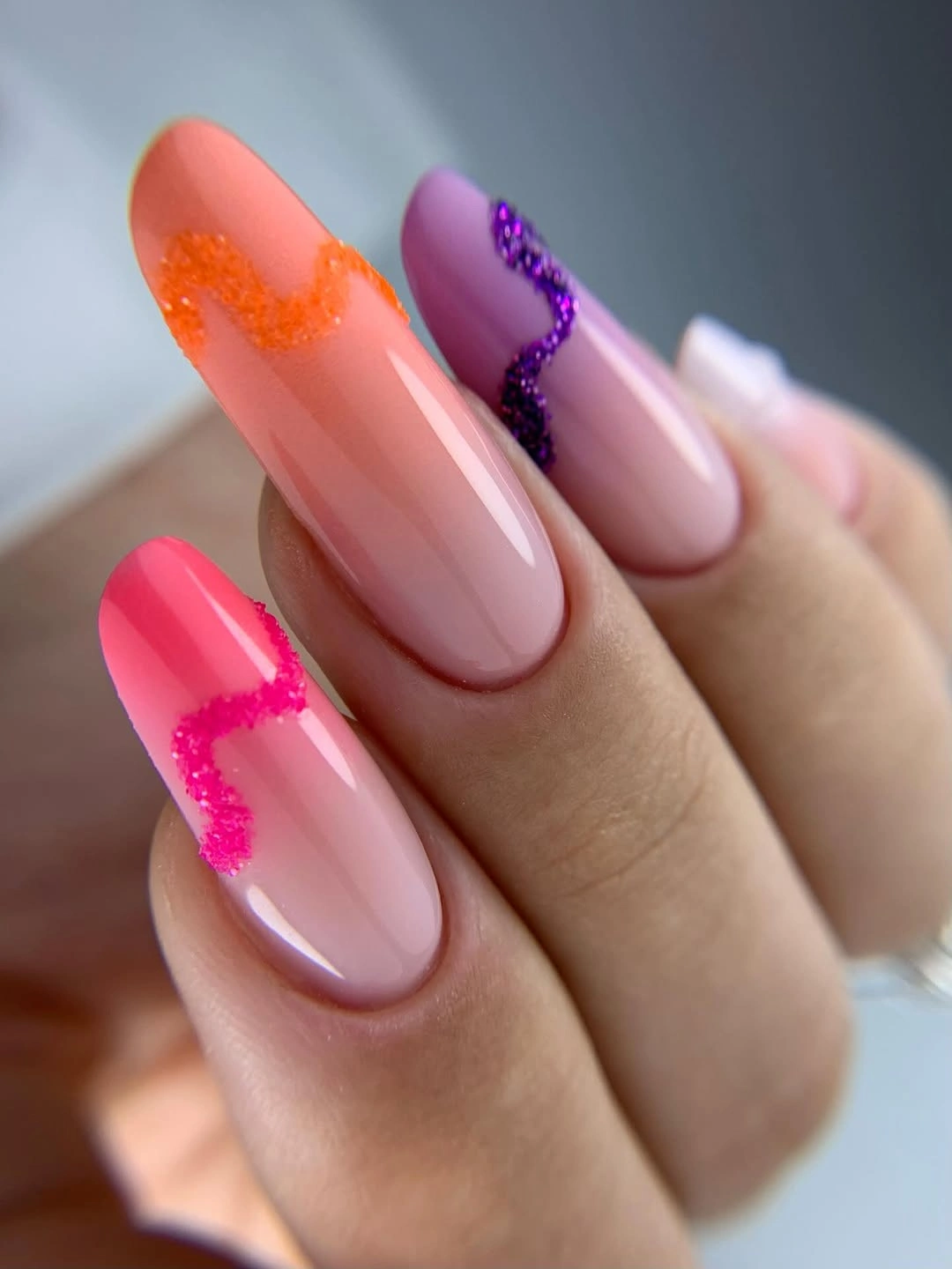 Long nude almond nails with neon pink and purple tips
