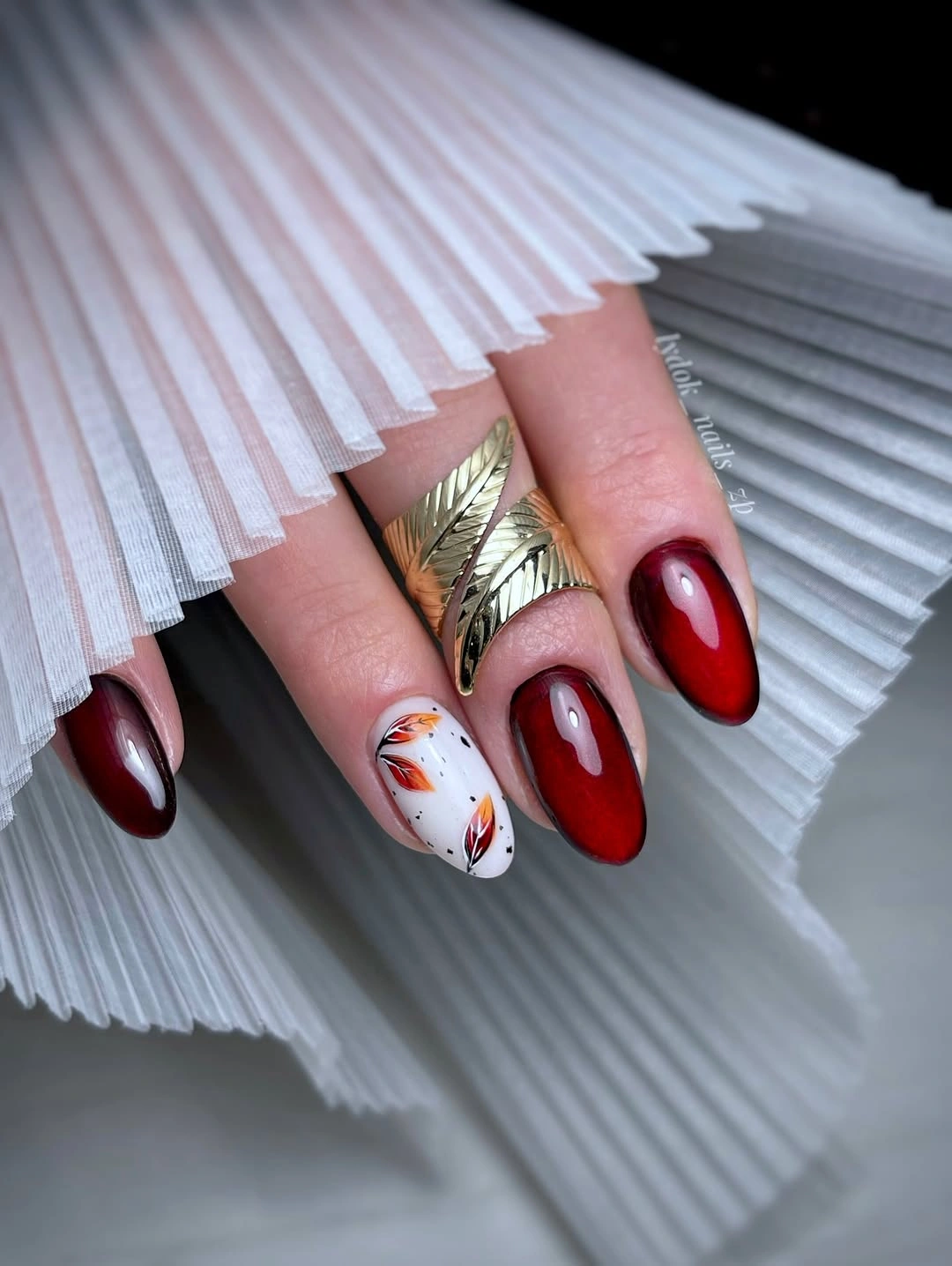 Medium almond burgundy nails with white and metallic accents