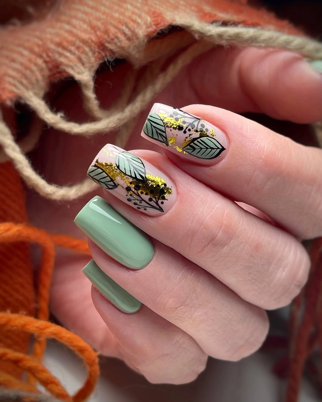 Short sage nails with detailed botanical accent art