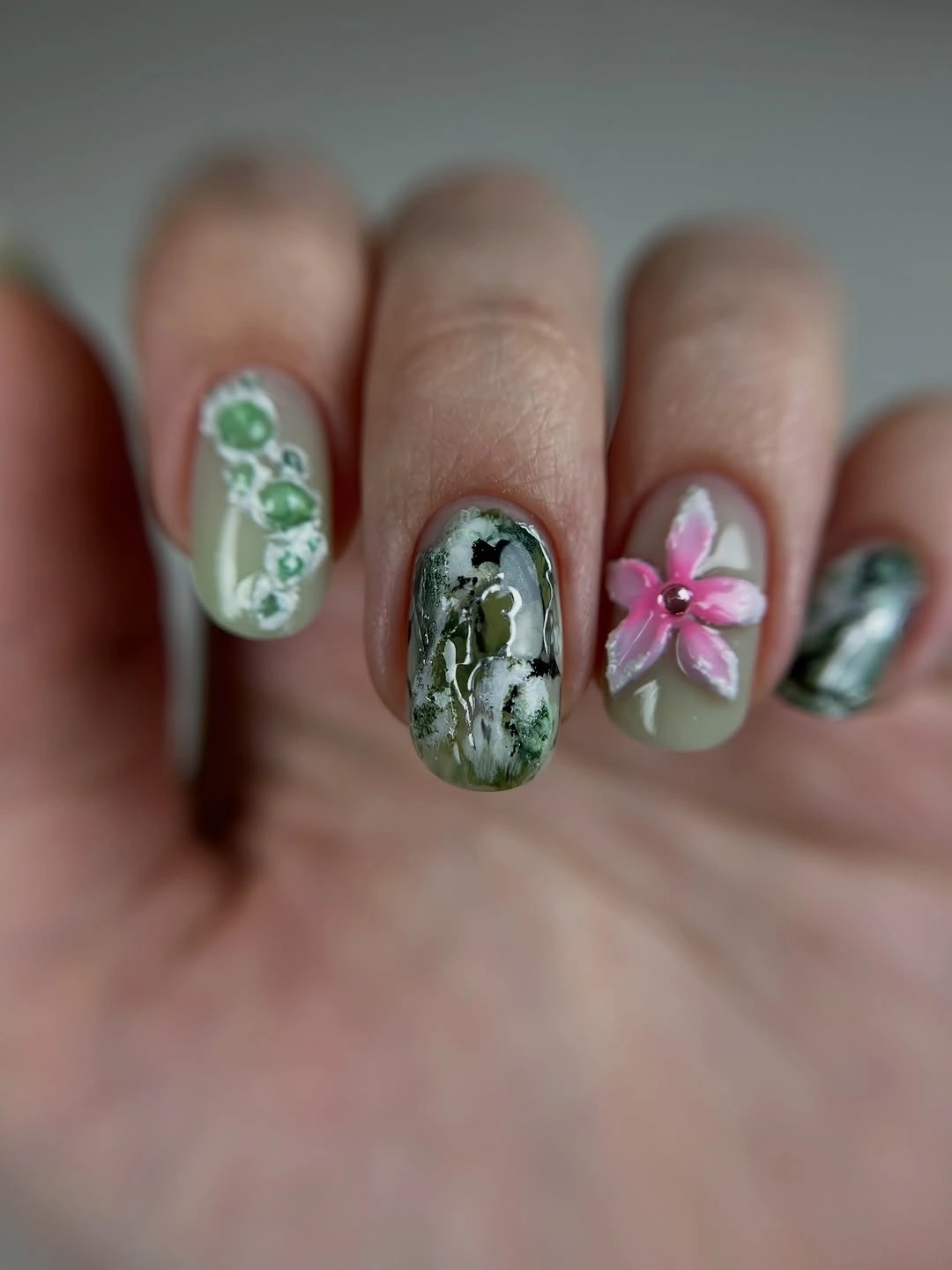 Short green gray nails with floral marble and pink accents