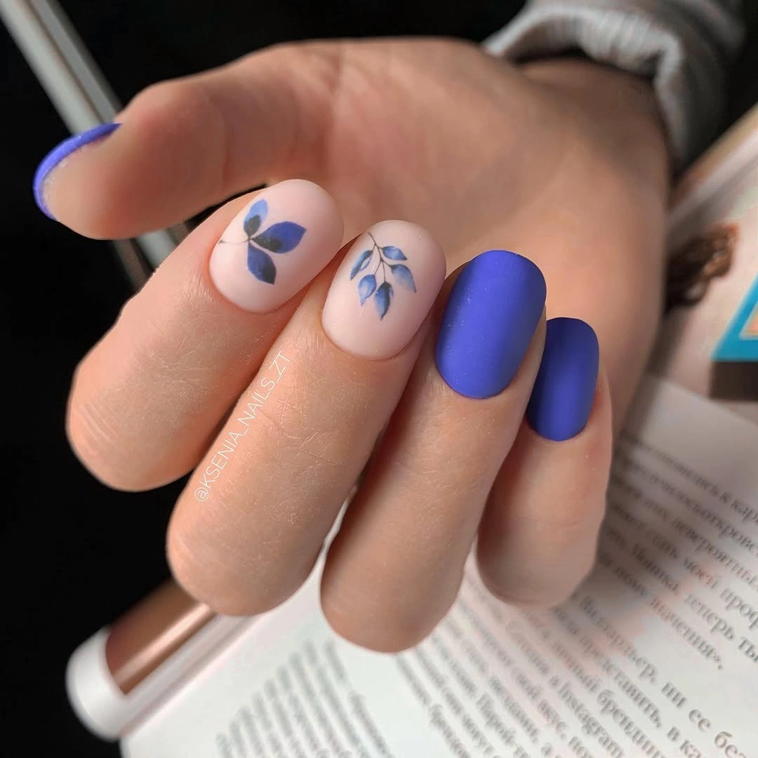 Blue nails with pale floral and leaf accent nails