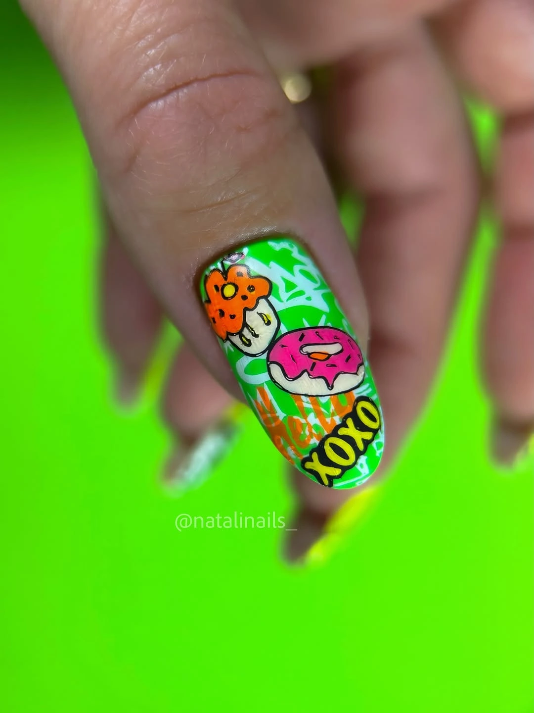Vivid green nail with colorful illustrated accent details
