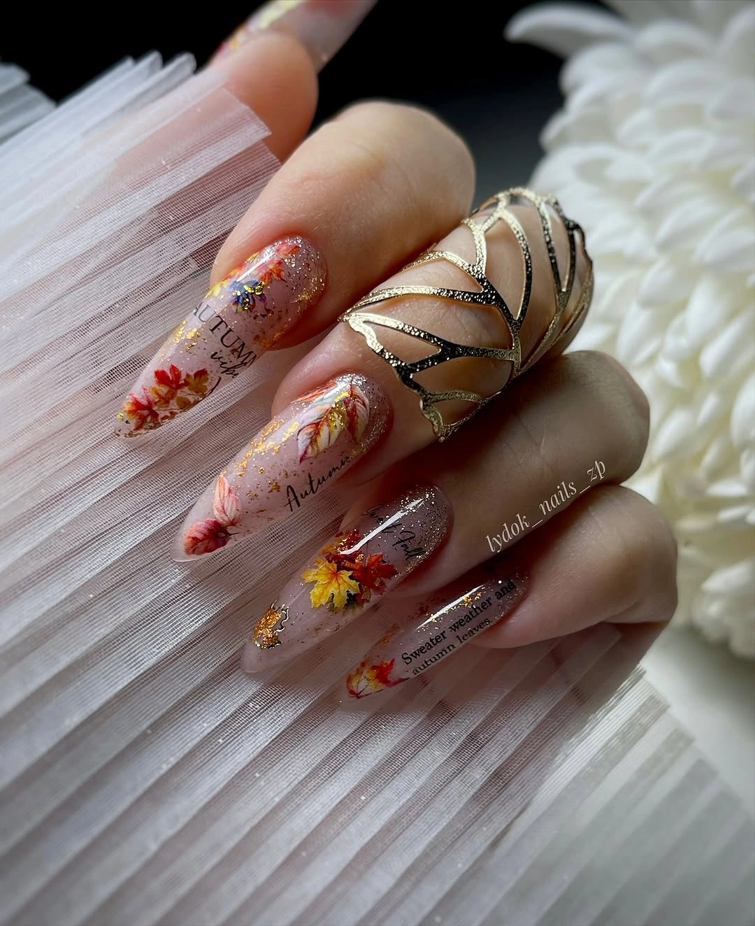 Very long clear nails with floral and gold accent details