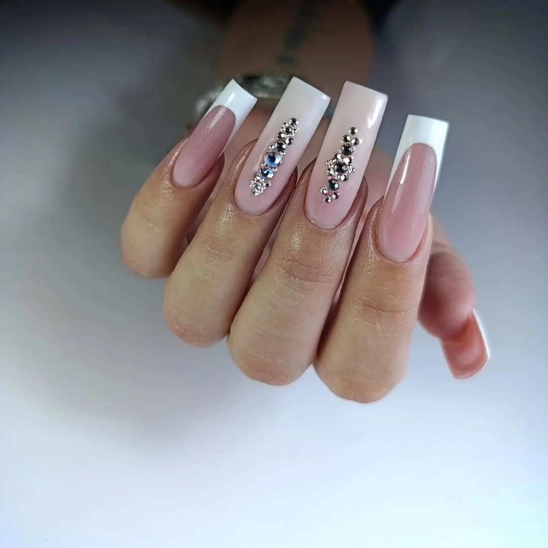 Long pale square nails with French tips and jeweled line accents